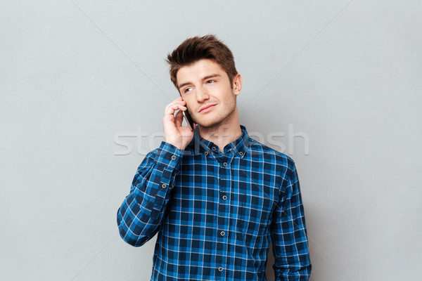 Knappe man permanente grijs muur praten telefoon Stockfoto © deandrobot