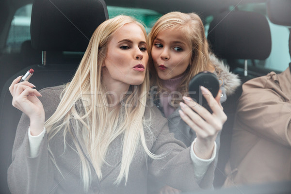 Young pretty woman doing makeup look at mirror Stock photo © deandrobot