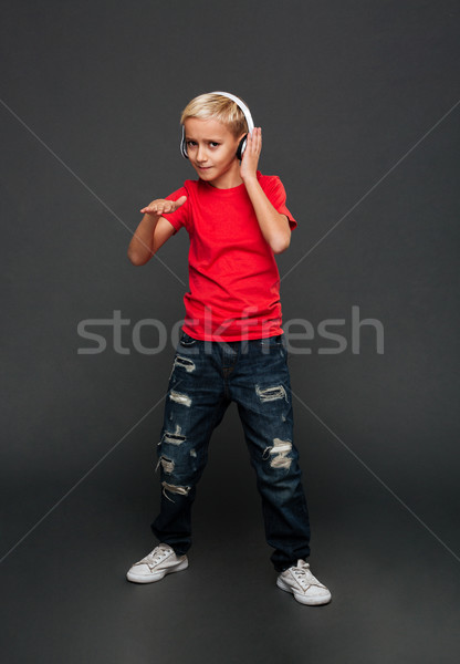 Emotional little boy child listening music with headphones dancing. Stock photo © deandrobot