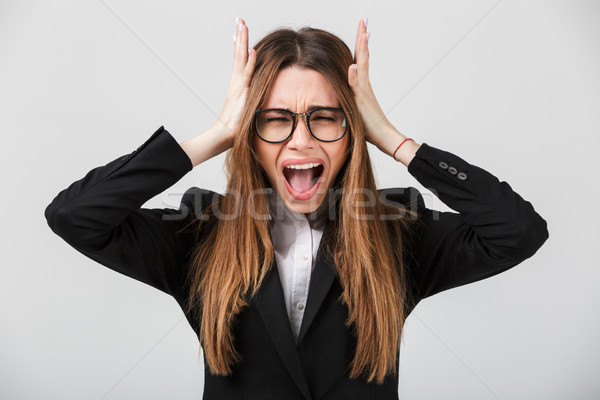 Young lady with closed eyes holding her head with hands isolated Stock photo © deandrobot