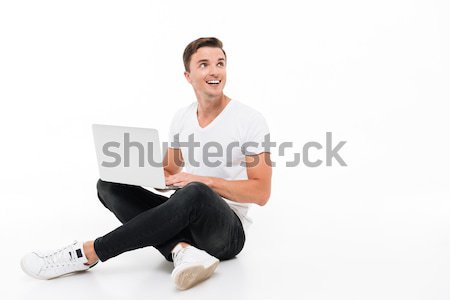 Portrait of an excited amused guy working on laptop Stock photo © deandrobot