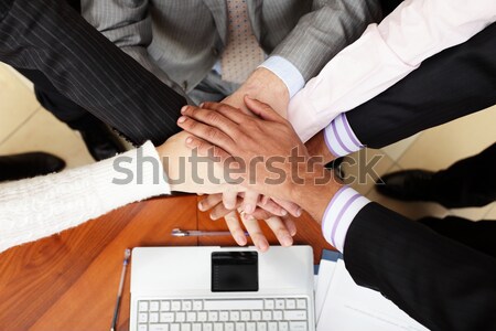 Image of business people hands on top of each other. View from above Stock photo © deandrobot