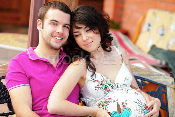 Young man hugs his pregnant wife outdoors Stock photo © deandrobot