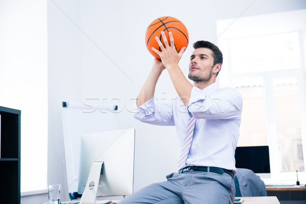 Businessman sitting on the table with ball  Stock photo © deandrobot