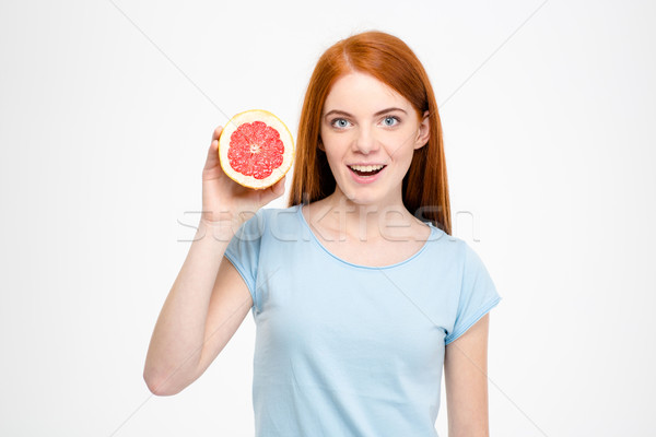 Izgatott vonzó derűs fiatal nő tart grapefruit Stock fotó © deandrobot
