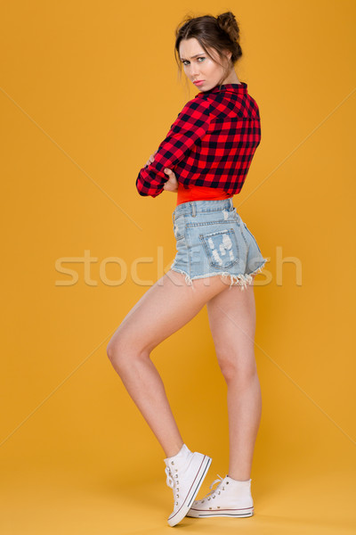 Attractive offended sad young woman standing with folded hands  Stock photo © deandrobot