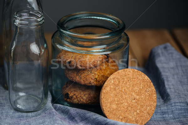 Oatmeal cookies in jar and empty glass bottles Stock photo © deandrobot