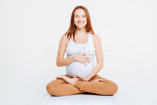 Happy pregnant woman sitting on the floor Stock photo © deandrobot