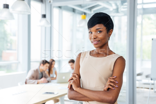 Geslaagd afrikaanse zakenvrouw permanente handen gevouwen Stockfoto © deandrobot