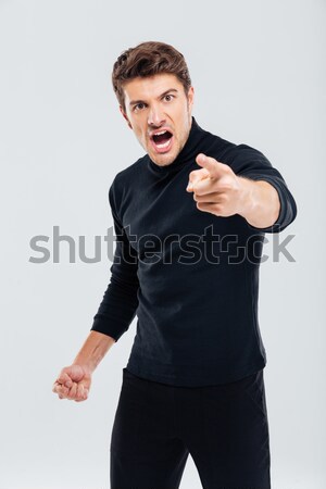 Angry furious young man shouting and pointing on you Stock photo © deandrobot