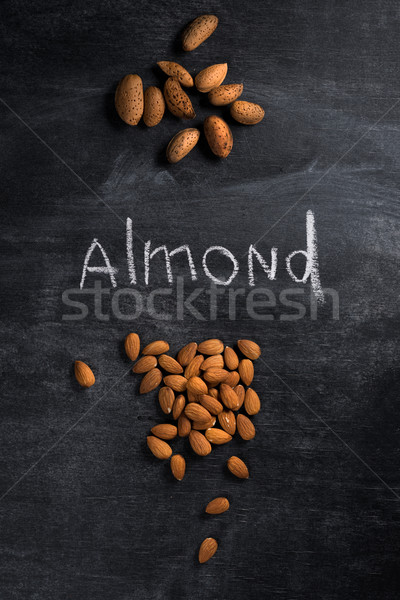 Almond over dark chalkboard background Stock photo © deandrobot