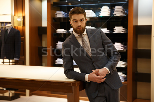 Man in suit standing near the table  shop Stock photo © deandrobot