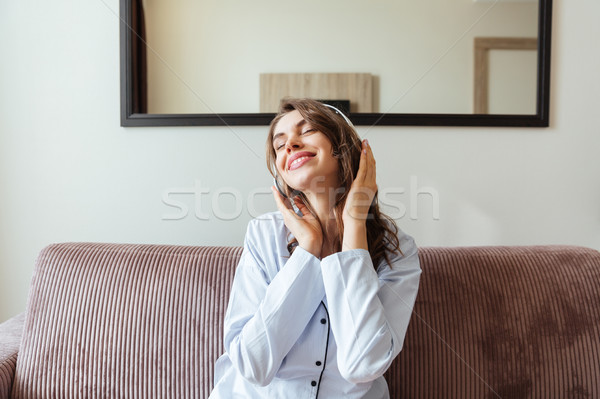 Happy young lady listening music Stock photo © deandrobot