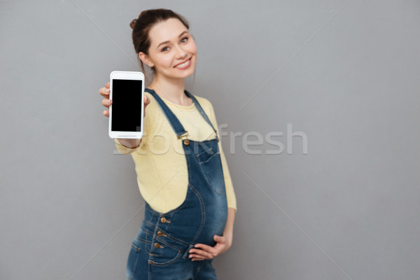 Foto stock: Sorridente · alegre · mulher · grávida · tela · telefone · móvel