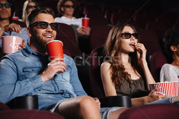 Happy friends sitting in cinema watch film eating popcorn Stock photo © deandrobot