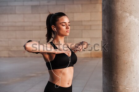 Vonzó sportoló zenét hallgat fülhallgató áll pihen Stock fotó © deandrobot