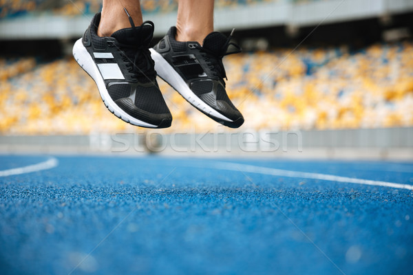 Közelkép férfi lábak sportcipők ugrik út Stock fotó © deandrobot