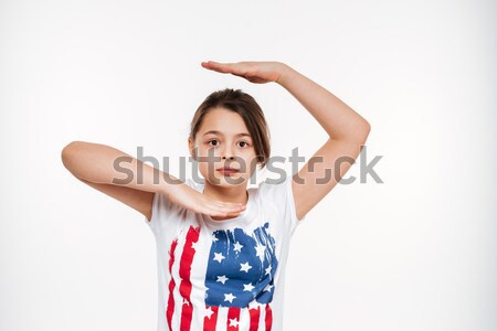 Portrait of a puzzled asian girl standing with hands Stock photo © deandrobot