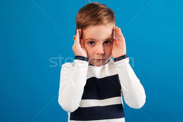 Young boy in sweater holding his hands near the eyes Stock photo © deandrobot