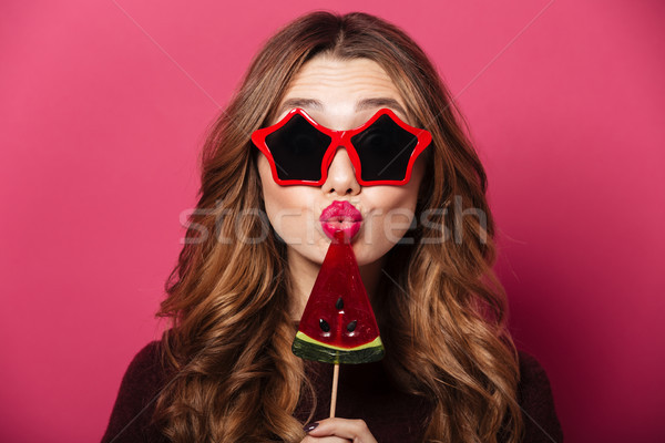 Funny lady wearing glasses eating candy. Stock photo © deandrobot