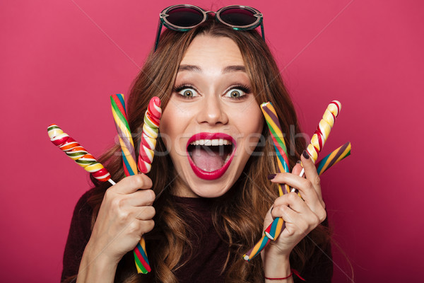 Surprised funny lady wearing glasses eating candy. Stock photo © deandrobot