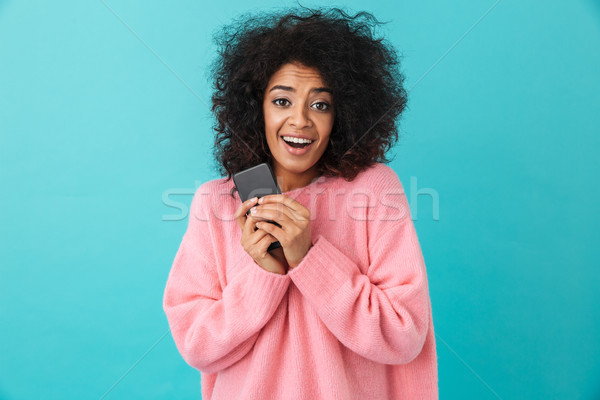 Image of american curly woman in pink shirt rejoicing and holdin Stock photo © deandrobot