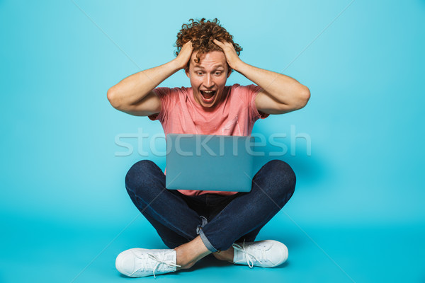Image of amazed or suprised hipster man 20s with brown curly hai Stock photo © deandrobot