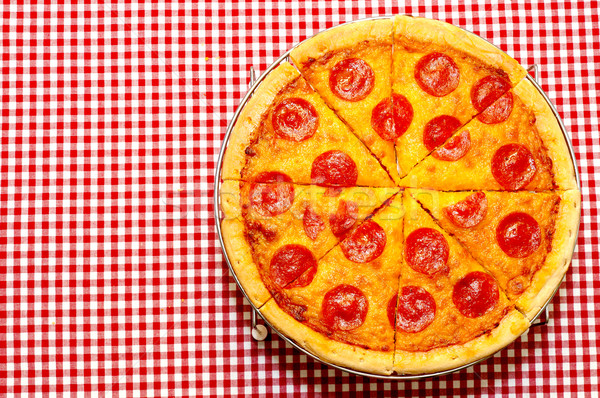 Intreg pepperoni pizza roşu fata de masa Imagine de stoc © dehooks