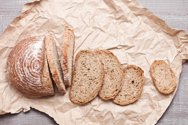 Freshly baked bread loaf with pieces on wood board Stock photo © DenisMArt