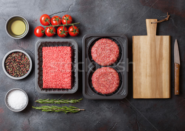 Tray with raw minced homemade beef meat with spices and herbs. Top view. On top of kitchen table bac Stock photo © DenisMArt