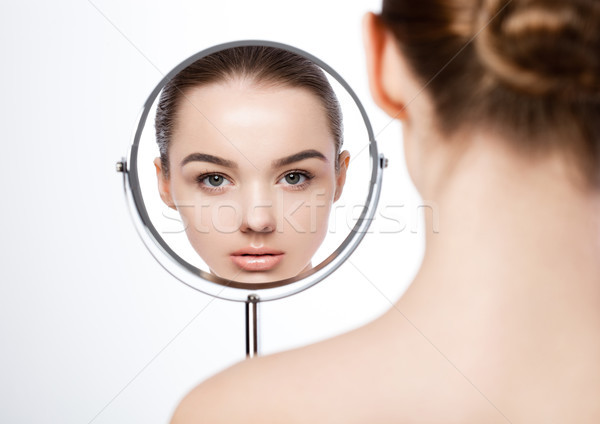 Beauty girl natural makeup looking in mirror  Stock photo © DenisMArt