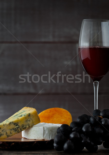 Glass of red wine with cheese selection and grapes Stock photo © DenisMArt