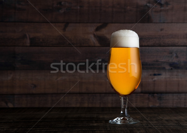 Glass of golden lager ale beer with foam on wood Stock photo © DenisMArt