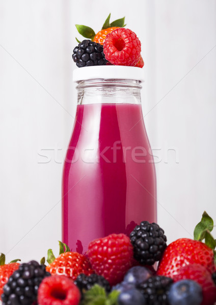 Glass bottle with fresh summer berries smoothie Stock photo © DenisMArt