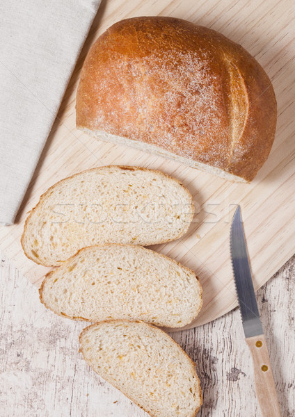 Freshly baked bread loaf with pieces on wood board Stock photo © DenisMArt