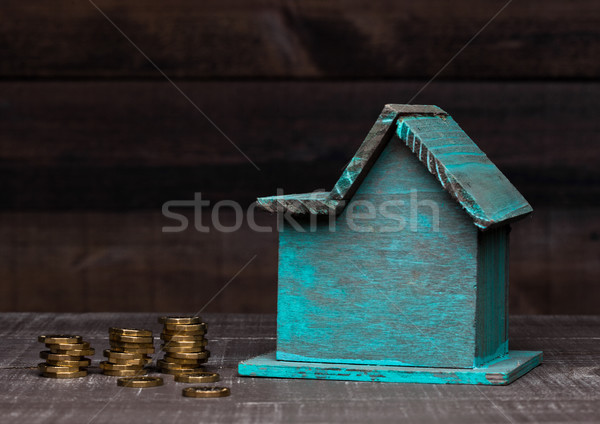 Wooden house model with coins next to it and hand Stock photo © DenisMArt