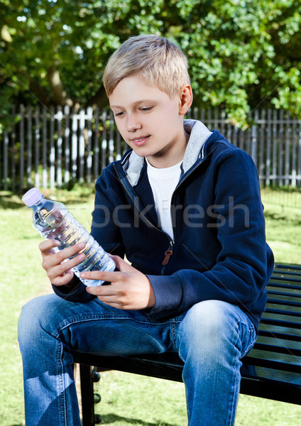 年輕 十幾歲的男孩 瓶 水上公園 坐在 長凳 商業照片 © DenisMArt