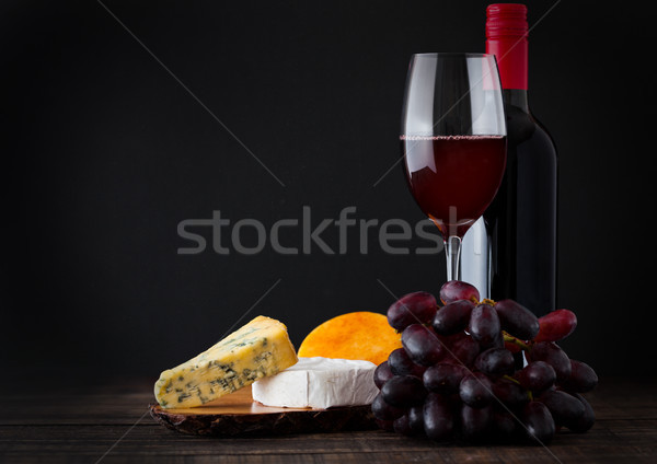 Stock photo: Bottle and glass of red wine with cheese selection