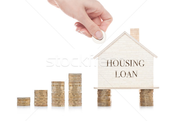 Wooden house model standing on coins and hand  Stock photo © DenisMArt