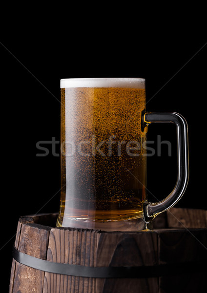 Stock photo: Cold glass of craft beer on old wooden barrel