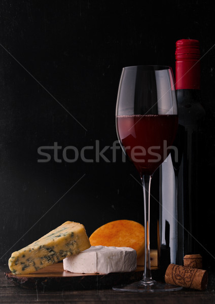 Bottle and glass of red wine with cheese selection Stock photo © DenisMArt