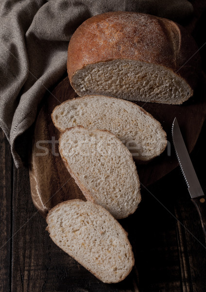 Freshly baked bread loaf with pieces on wood board Stock photo © DenisMArt