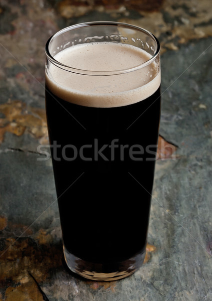 Glass of stout beer top with white foam Stock photo © DenisMArt