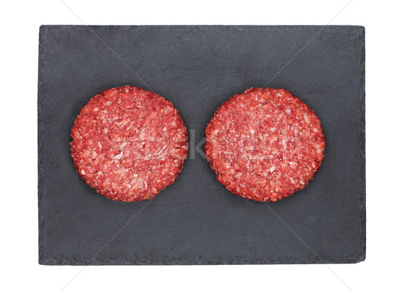 Raw fresh beef burgers on stone plate Stock photo © DenisMArt
