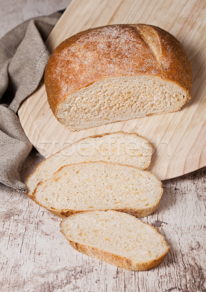 Freshly baked bread loaf with pieces on wood board Stock photo © DenisMArt