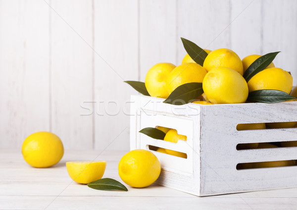 Fresh raw lemons in white wooden box with leaves Stock photo © DenisMArt