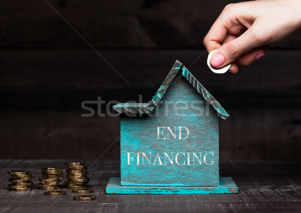 Wooden house model with coins next to it and hand Stock photo © DenisMArt