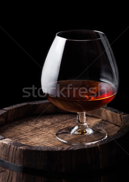 Stock photo: Glass of cognac brandy drink on top of wooden barrel.