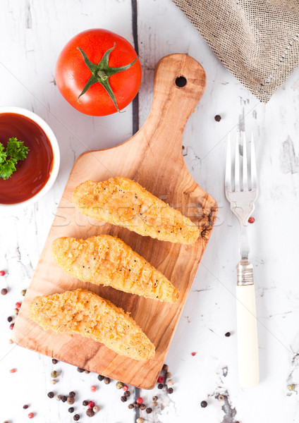 Fried chicken dippers on chopping board with sauce Stock photo © DenisMArt