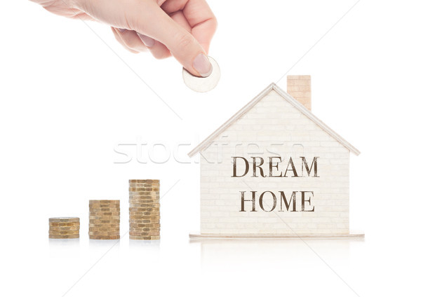 Wooden house model with coins next to it and hand Stock photo © DenisMArt